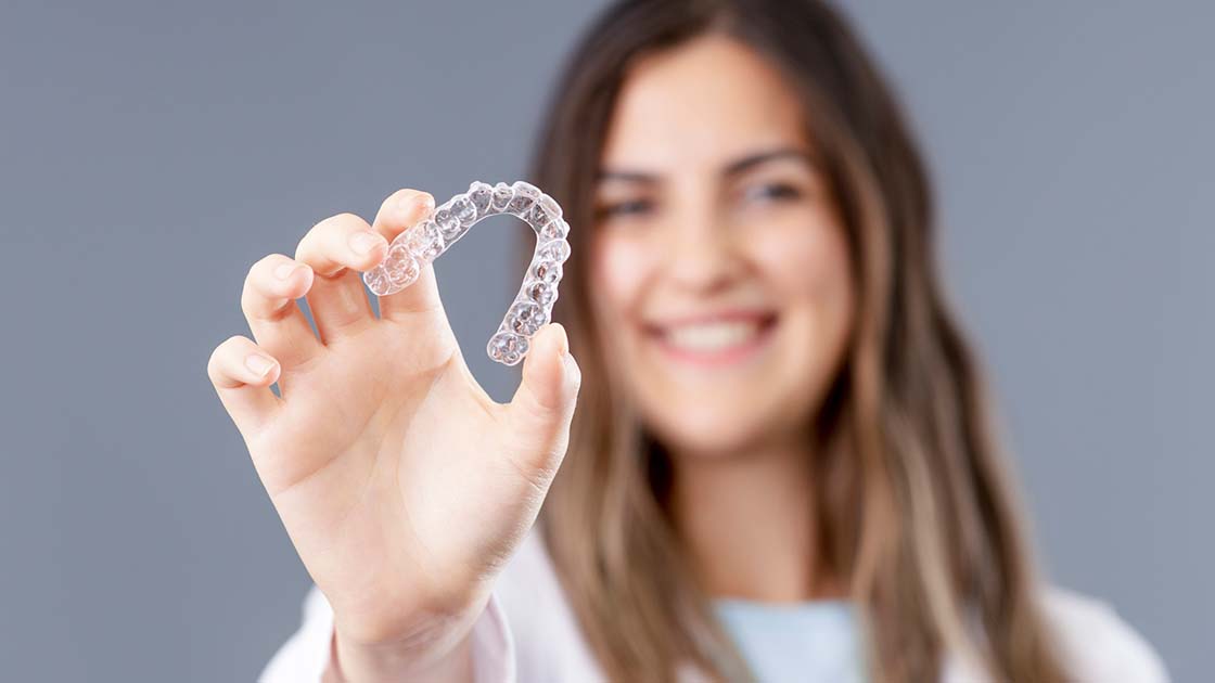 Teen holding aligners